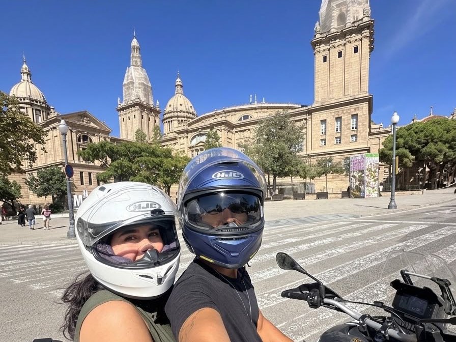 Co-rider couple on a motorcycle in front of the Museu Nacional d'Art de Catalunya on Montjuic