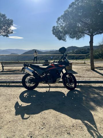 Motorcycle parked under a pine tree at a lookout on Tibidabo, Barcelona