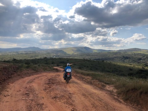 Rider on a dirt road above a wide valley in the Carrancas region
