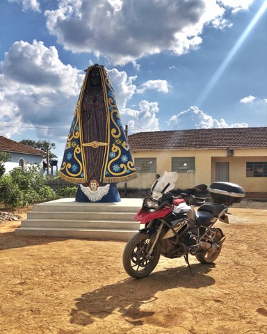 Roadside shrine next to a parked motorcycle on a Minas Gerais back road
