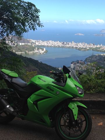 Moto deportiva verde en un mirador sobre la laguna y las playas de la Zona Sul de Río de Janeiro