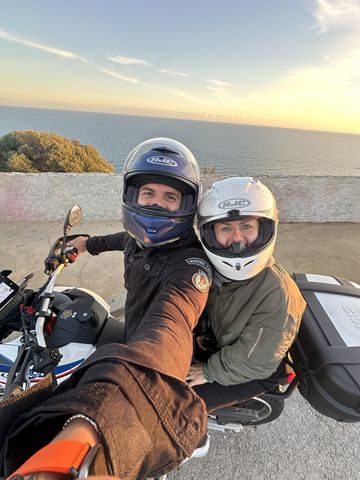 Rider and passenger on a motorcycle at the Garraf coast, with the Mediterranean behind