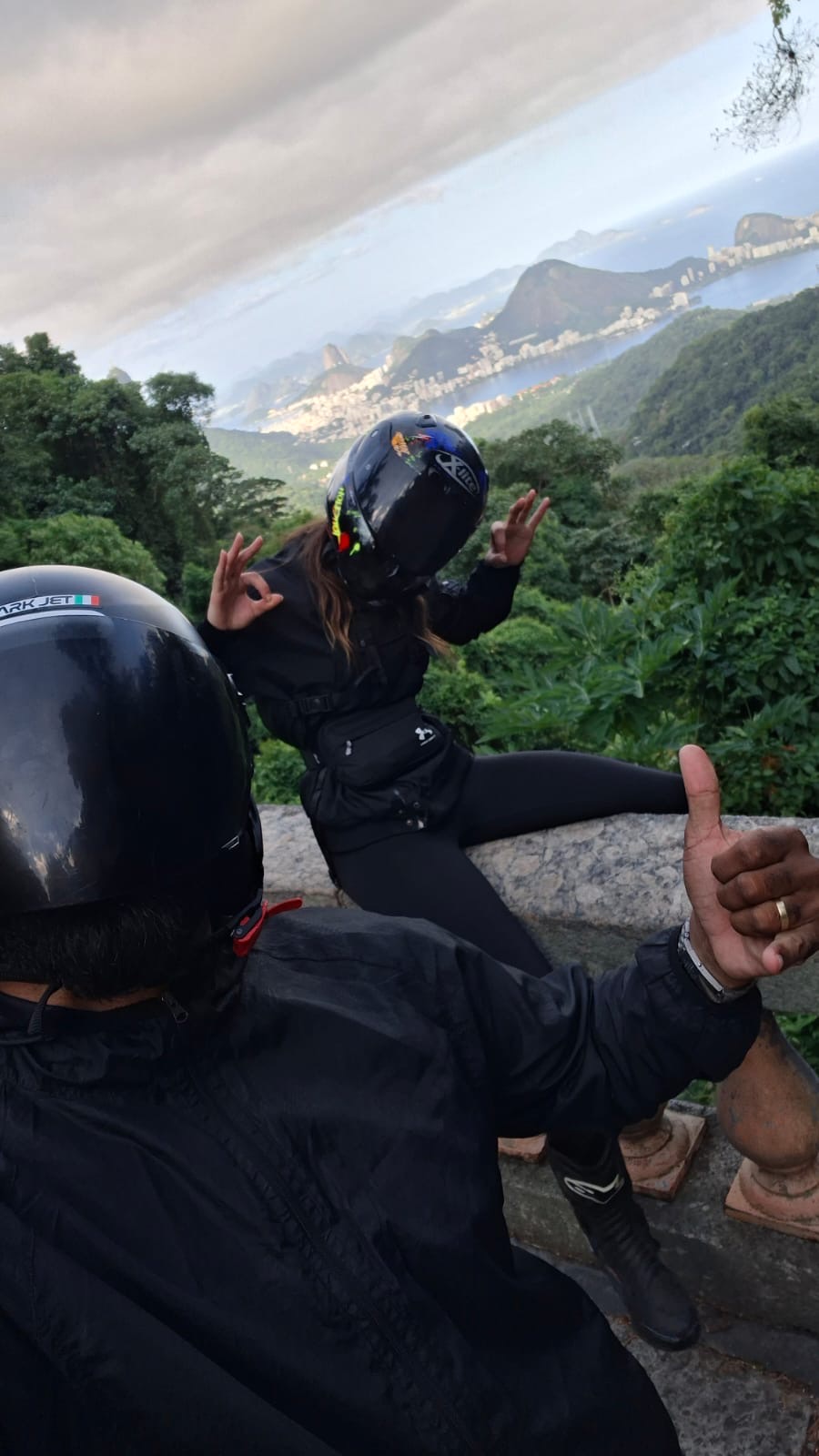 Passenger giving a thumbs up from the back seat on a forest road in Rio